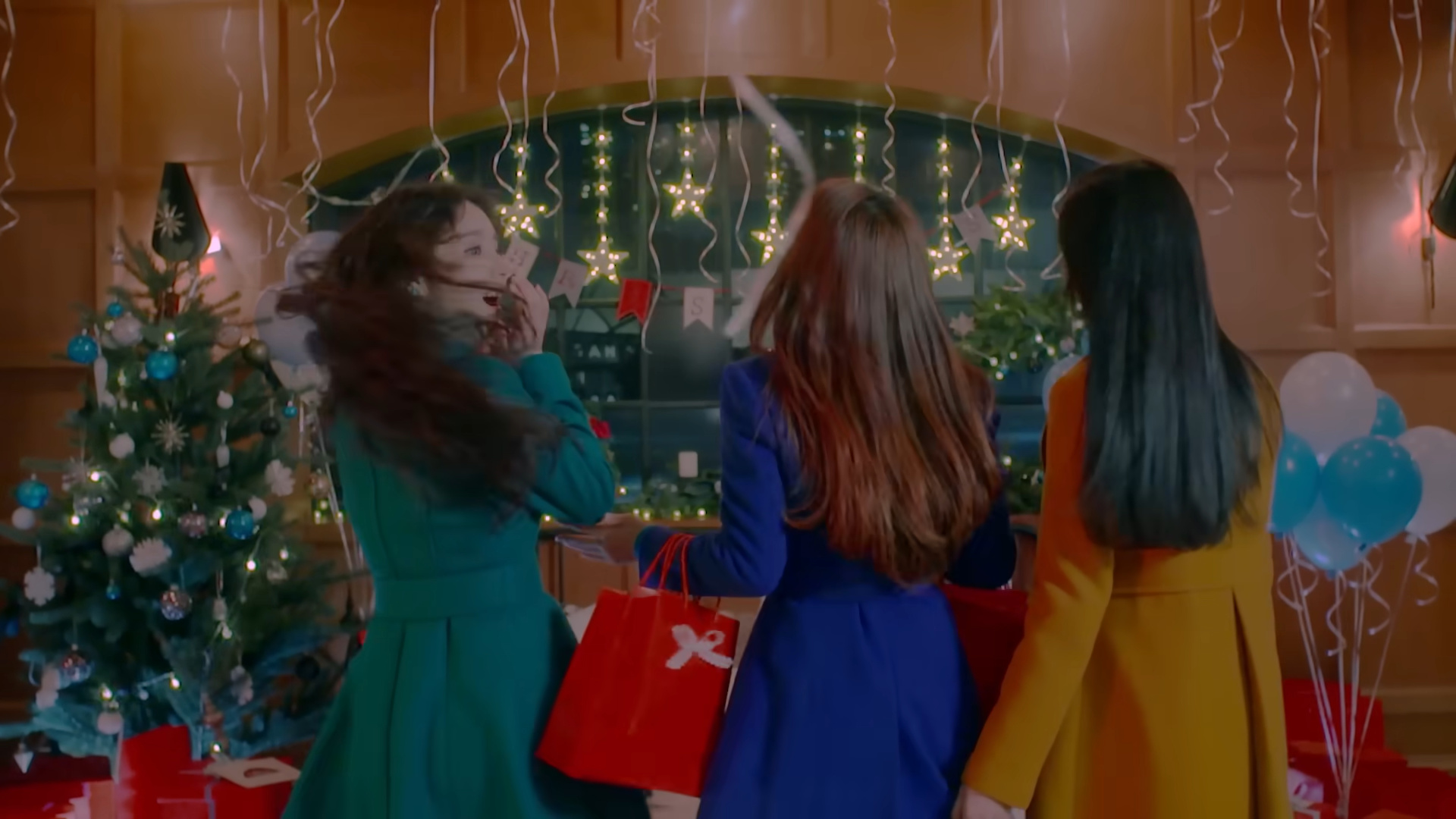 Heejin, Haseul, and Hyunjin looking at Christmas decorations, from 'The Carol' music video.